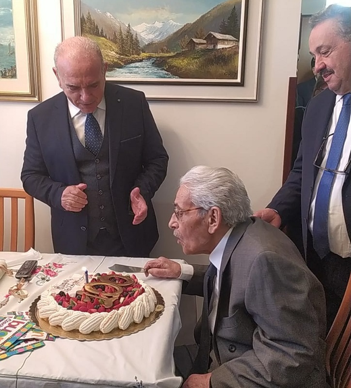 Un uomo con la torta di compleanno della holding di sorriso